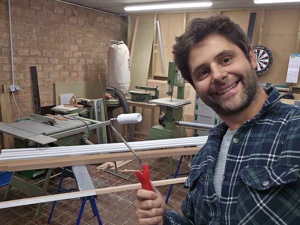 Man in houtatelier werkt aan houten wandlatten voor modulair wandopbergsysteem WandOrde