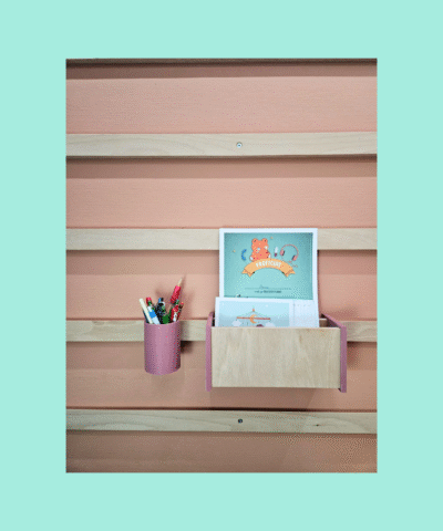 WandOrde modulair wandsysteem met roze penhouder en houten boekenvak, gemonteerd op wand