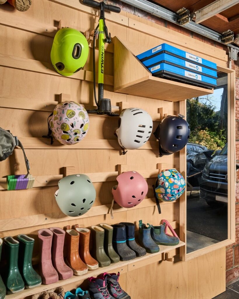 WandOrde modulair wandsysteem in garage met opbergruimte voor fietshelmen, kinderlaarzen, schoenen, step en mappen.