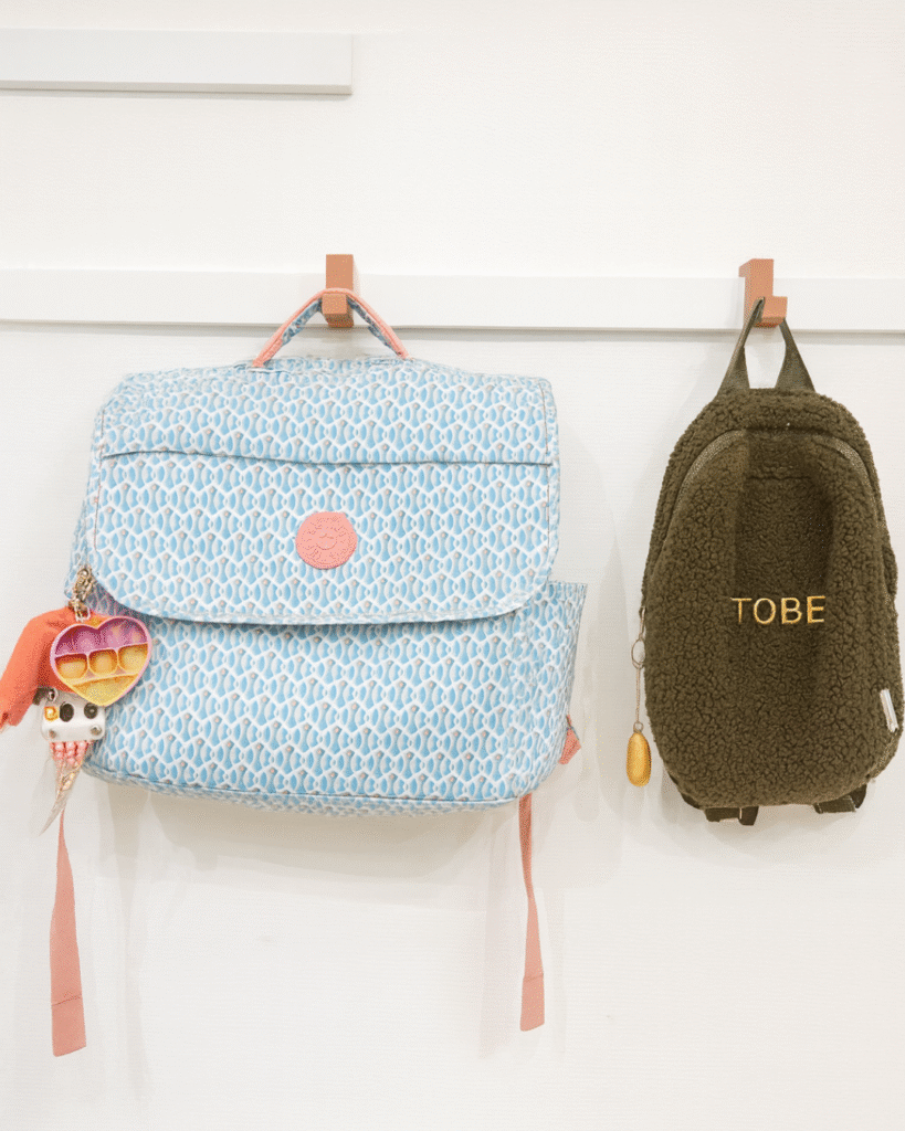 Boekentassen opgehangen aan WandOrde modulair wandsysteem in inkomhal of kinderkamer