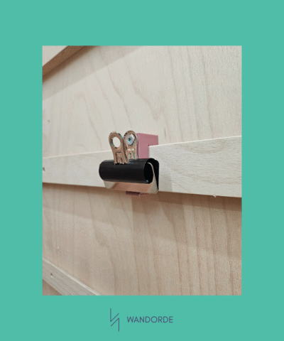 Klemhouder van WandOrde bevestigd op horizontale lat van modulair wandsysteem