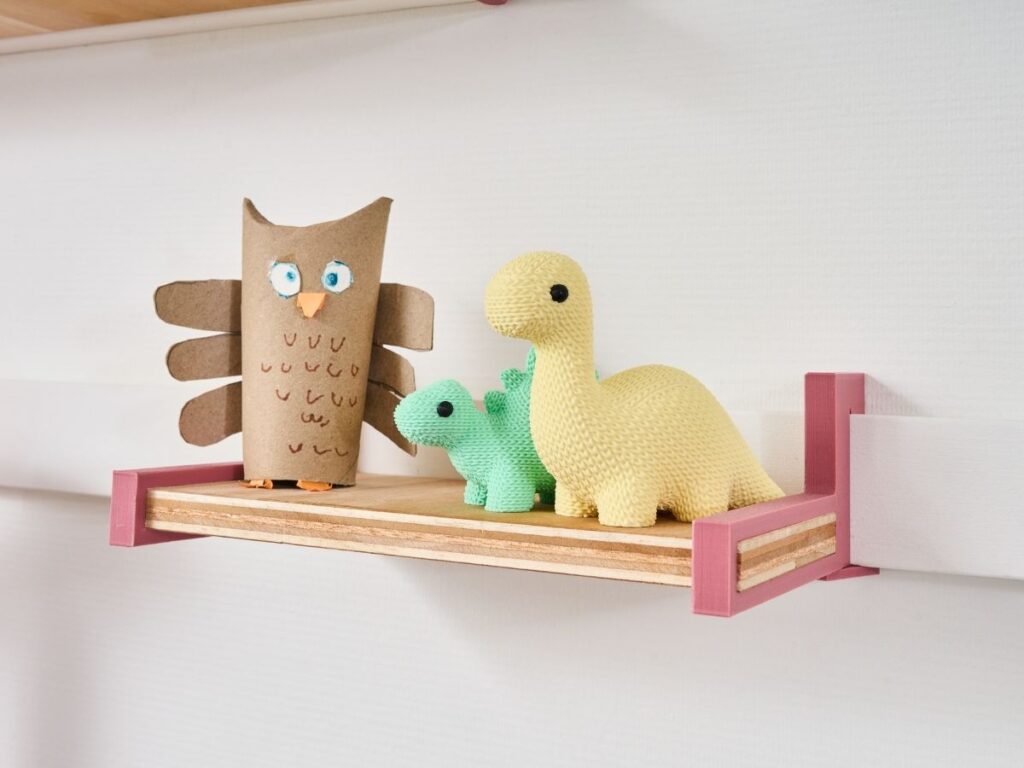 Roze WandOrde legger met kinderspeelgoed en decoratie tegen een witte wand.