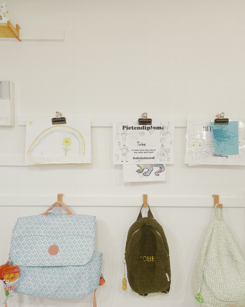 Kindertekeningen en diploma’s opgehangen met klemhouders op WandOrde wandsysteem