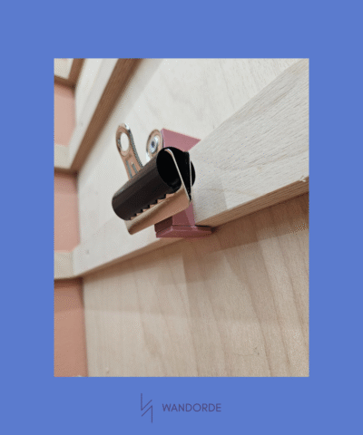 WandOrde klemhouder gemonteerd op houten modulair wandsysteem in huiselijke setting